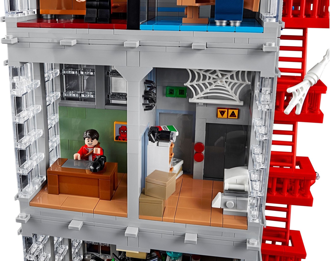 Peter Parker minifigure at his desk inside the LEGO Daily Bugle 76178, with a spider web element and the lift shaft beside him